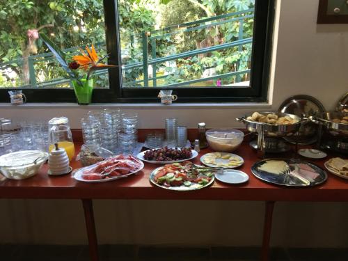 a table with plates of food on it with a window at Kastro Studios Apartments in Myrtos