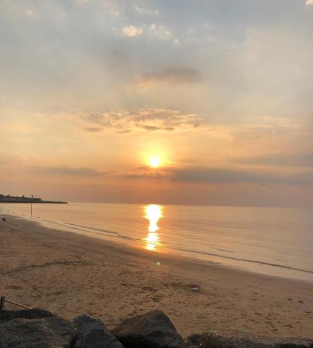 a sunset on a beach with the sun setting at Garden Oasis in Margate