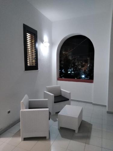 a living room with chairs and a table and a window at Villa Iavernaro in Pulsano