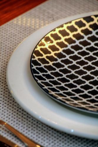 a black and yellow plate on a table at 23 On Glen Guest House in Port Elizabeth