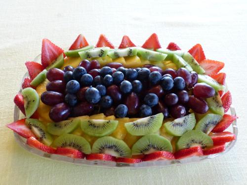 a fruit salad on a plate with kiwis and fruit at Halcyon Heights B&B/Inn in Homer