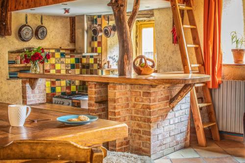 cocina con encimera de madera y pared de ladrillo en The Dragon Barn - Studio en Ascou