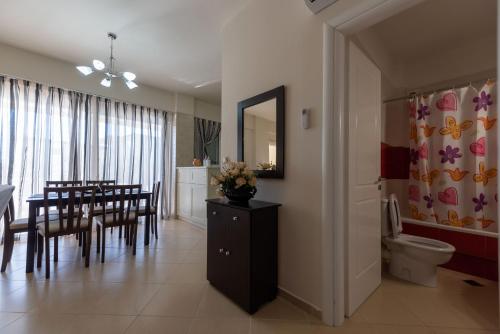 a dining room with a dining table and a bathroom at Grand Suites with Private Pools in Kalamata