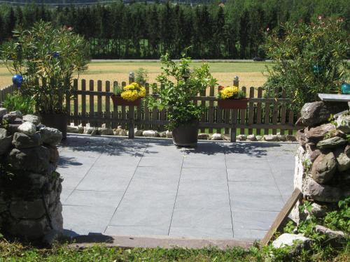 a garden with potted plants and a wooden fence at Schloss Manndorf Gästehaus in Kötschach