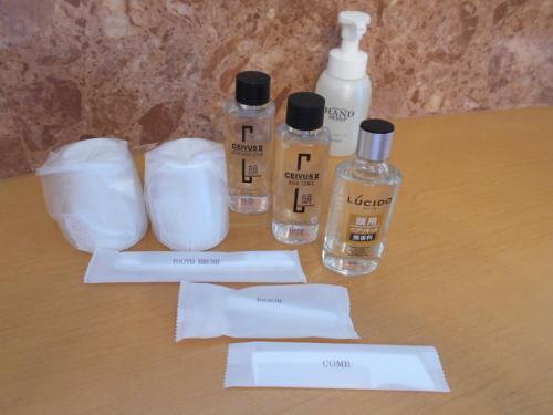 a table with three bottles of soap and toilet paper at Nishikawaguchi Station Hotel Stay Lounge in Kawaguchi