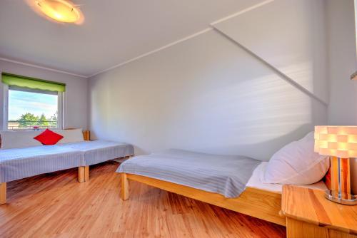 a bedroom with two beds and a window at Domki przy zalewie in Kamień Pomorski
