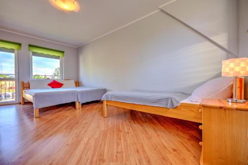 a bedroom with two beds and a window at Domki przy zalewie in Kamień Pomorski