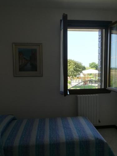 a bedroom with a bed and a window at Villa Delux in Correzzola