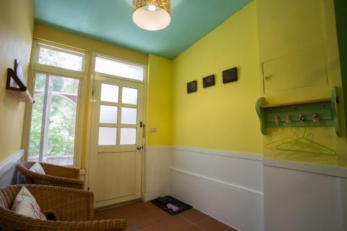 a room with yellow walls and a door and a window at Xiangyang Tianyuan in Sanyi