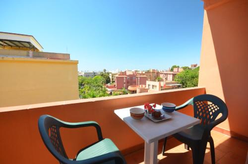 una mesa pequeña y sillas en un balcón con vistas en Hostal La Palmera, en Torremolinos