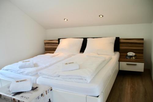 a bedroom with two beds with white sheets at Haus am Donausee (House at the Danube Lake Beach) in Weitenegg