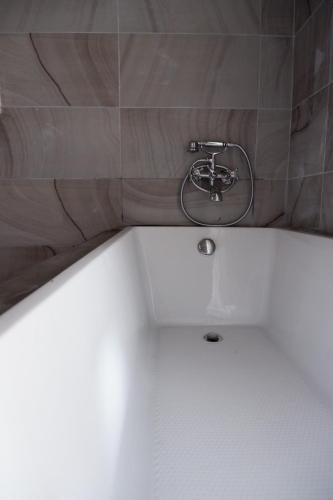 a bathroom with a sink and a bath tub at Black Elephant Boutique in Surat Thani