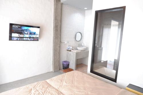 a bathroom with a mirror and a sink and a bed at Black Elephant Boutique in Surat Thani