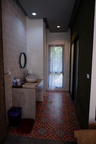 a bathroom with a sink and a mirror at Black Elephant Boutique in Surat Thani