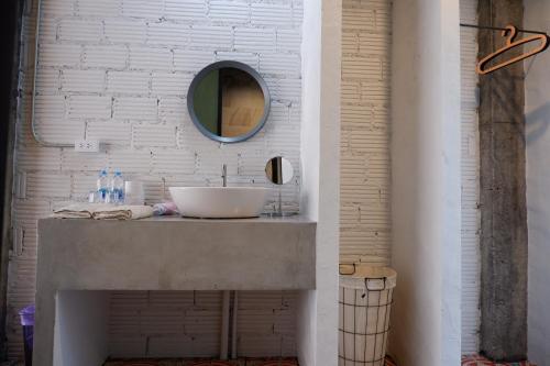 a bathroom with a sink and a mirror on a wall at Black Elephant Boutique in Surat Thani
