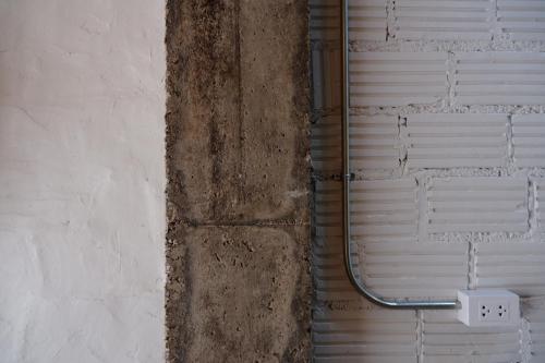 a wall with a metal shower in a bathroom at Black Elephant Boutique in Surat Thani