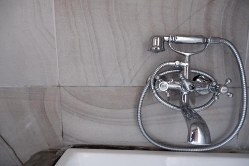a shower head in a bathroom with a tub at Black Elephant Boutique in Surat Thani