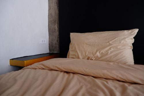 an unmade bed with a pillow and a pillowcase at Black Elephant Boutique in Surat Thani