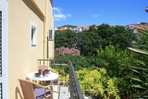 uma varanda com mesa, cadeiras e plantas em Villa Marinesa em Hvar