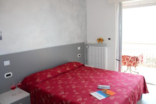 a bedroom with a bed with a red bedspread at Hotel Casa Gagliardi in Brenzone sul Garda