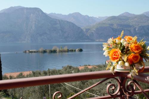 a bouquet of flowers sitting on a railing overlooking a lake at Hotel Casa Gagliardi in Brenzone sul Garda