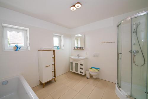 La salle de bains est pourvue d'une douche, de toilettes et d'un lavabo. dans l'établissement Ferienwohnungen Rügen Findling Breege, à Breege