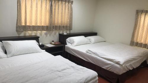two beds in a small room with curtains at SuWaNa in Leye