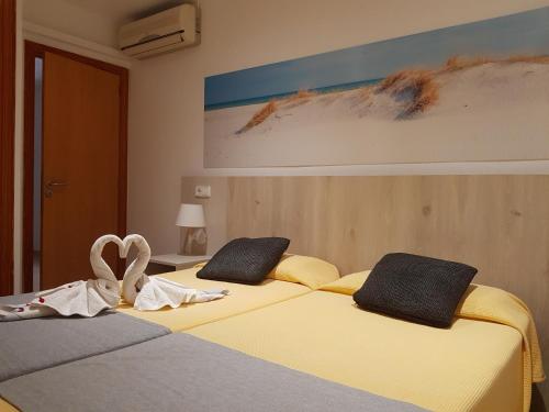 two beds sitting next to each other in a bedroom at Venecia Apartments in Port d'Alcudia
