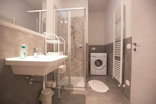 a bathroom with a sink and a shower with a washing machine at Casa Lorenzo in Bardolino