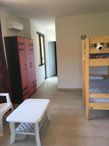 a room with a bunk bed and a table and a bench at Zapovedni Rai in Primorsko
