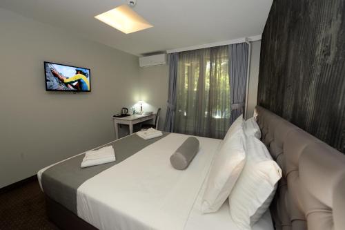 a hotel room with a large bed with white pillows at Hotel Alexandar II in Skopje