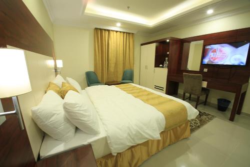 a hotel room with a bed and a television at ضيافة بلس شقق مخدومة أقتصادية Dyafah plus 1 in Jeddah