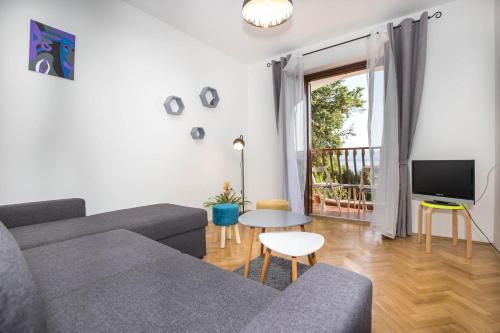 a living room with a couch and a tv at Apartman Šesna in Bol