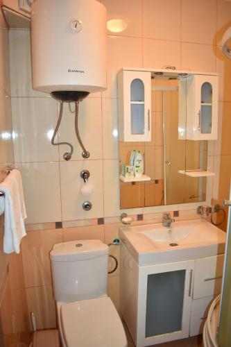 a bathroom with a toilet and a sink and a mirror at Apartments Contessa in Ulcinj