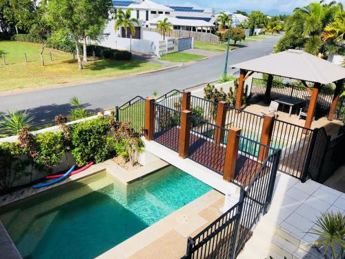 an overhead view of a swimming pool with a fence at Luxury marina view Apartment cairns in Trinity Beach