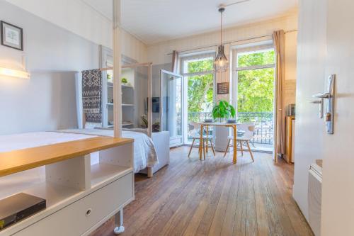 a bedroom with a bed and a dining room with a table at Studio Clemenceau in Aix-les-Bains