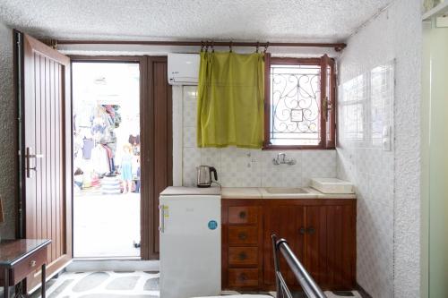 uma cozinha com um frigorífico branco e uma janela em Studio Eleni em Míconos