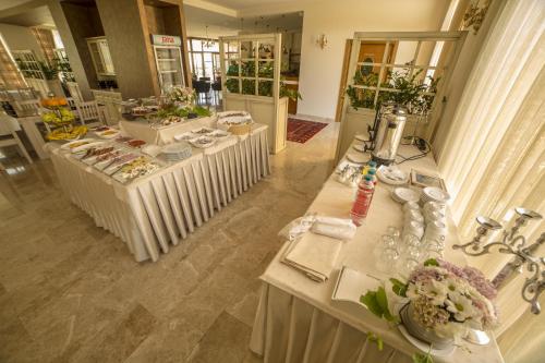 a group of tables in a room with flowers on them at Hotel Quercus in Međugorje