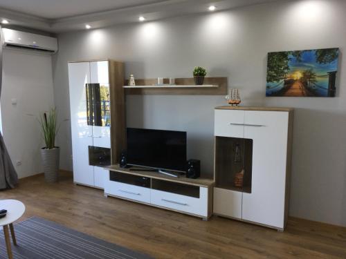 ein Wohnzimmer mit einem großen weißen Entertainment-Center mit einem Flachbild-TV in der Unterkunft Apartament Żeglarski Wilkasy in Wilkasy