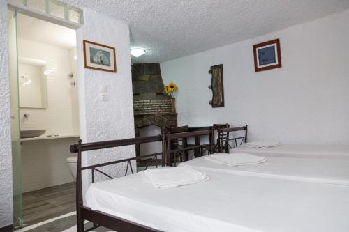 two beds in a room with a fireplace at Studio Eleni in Mikonos