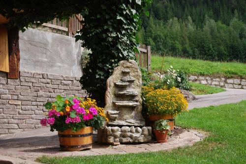 a stone statue and flowers in pots next to a building at Haus Benedikt in Heiligenblut