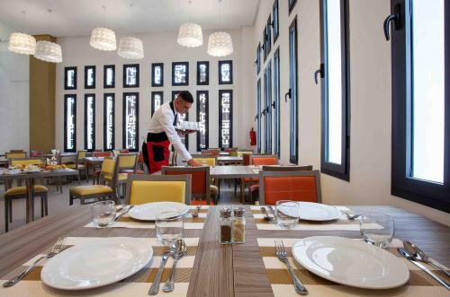Un homme debout dans une salle à manger avec une table dans l'établissement Relax Hotel Casa Voyageurs, à Casablanca