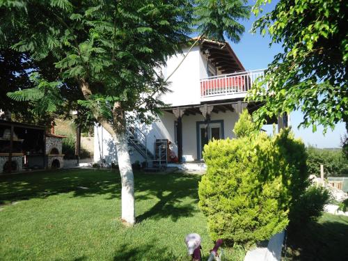 a house with a tree and two dogs in the yard at Alexandra Homestay in Kalavárda