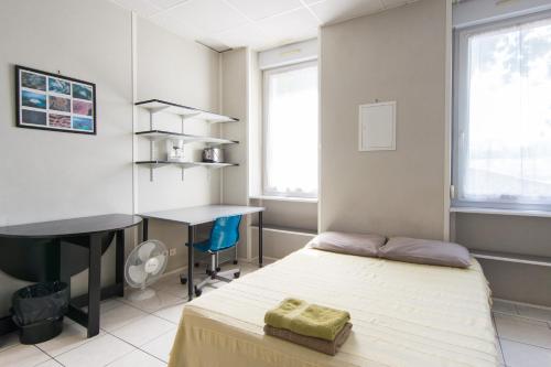 a bedroom with a bed and a desk and a table at Résidence Carpe Diem in Marseille