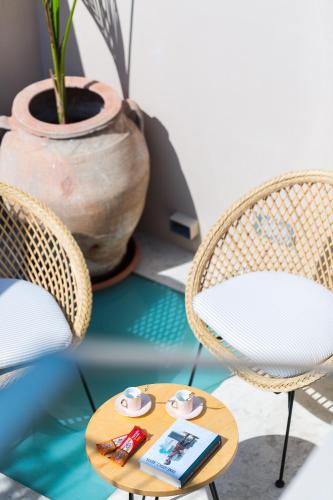 two chairs and a table with a book on it at Neratze Hammam Suites in Rethymno Town