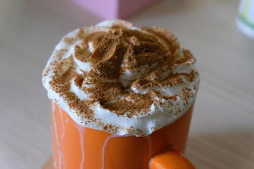 a cup of coffee with a donut on top of it at Casa Carmina Hostel in Muros de Nalón