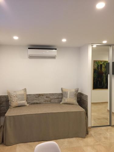 a bedroom with a bed with a wall mounted air conditioner at Pasaje La Camboria in Fuengirola