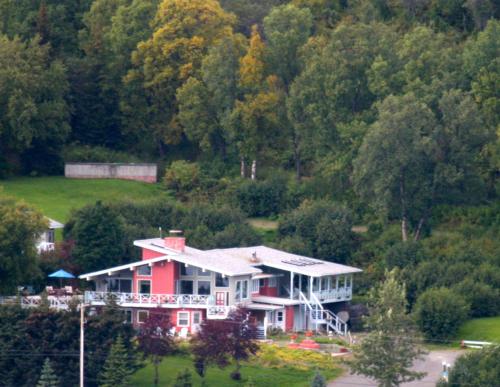 a large red house in the middle of a forest at Halcyon Heights B&B/Inn in Homer
