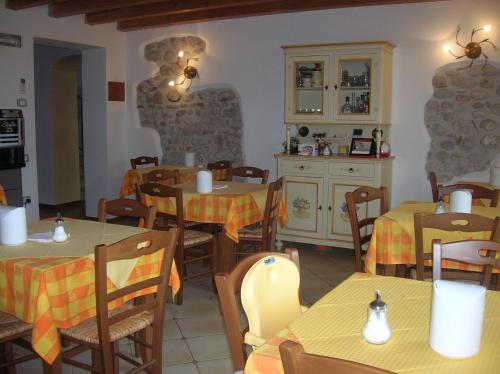 a restaurant with tables and chairs and a kitchen at Agriturismo Colombarola in Sona