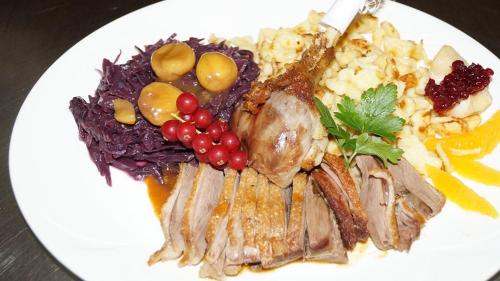 a white plate of food with meat and vegetables at Hotel Restaurant Kreuz in Kaiserstuhl